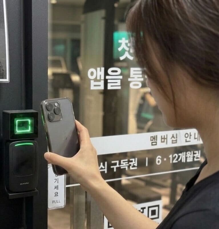 매장 정문 QR 리더기에 폰 화면을 가까이 대어 인식하는 모습